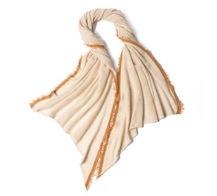 Lightweight oatmeal cashmere scarf draped over wooden chair showing plain knit texture