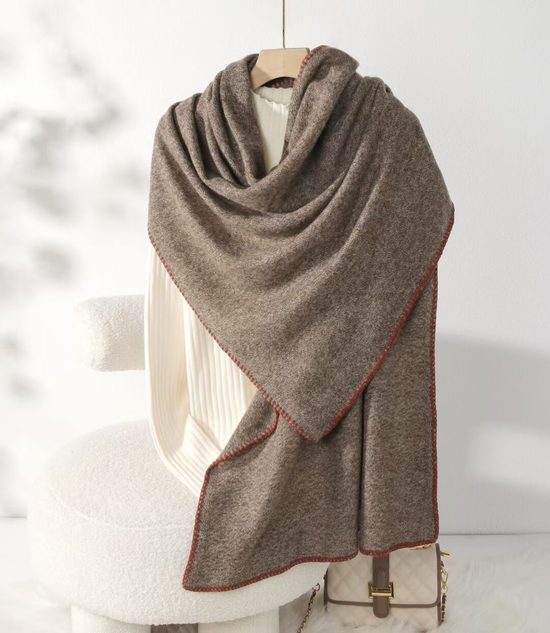 Brown 100% cashmere scarf draped over a chair with a white background