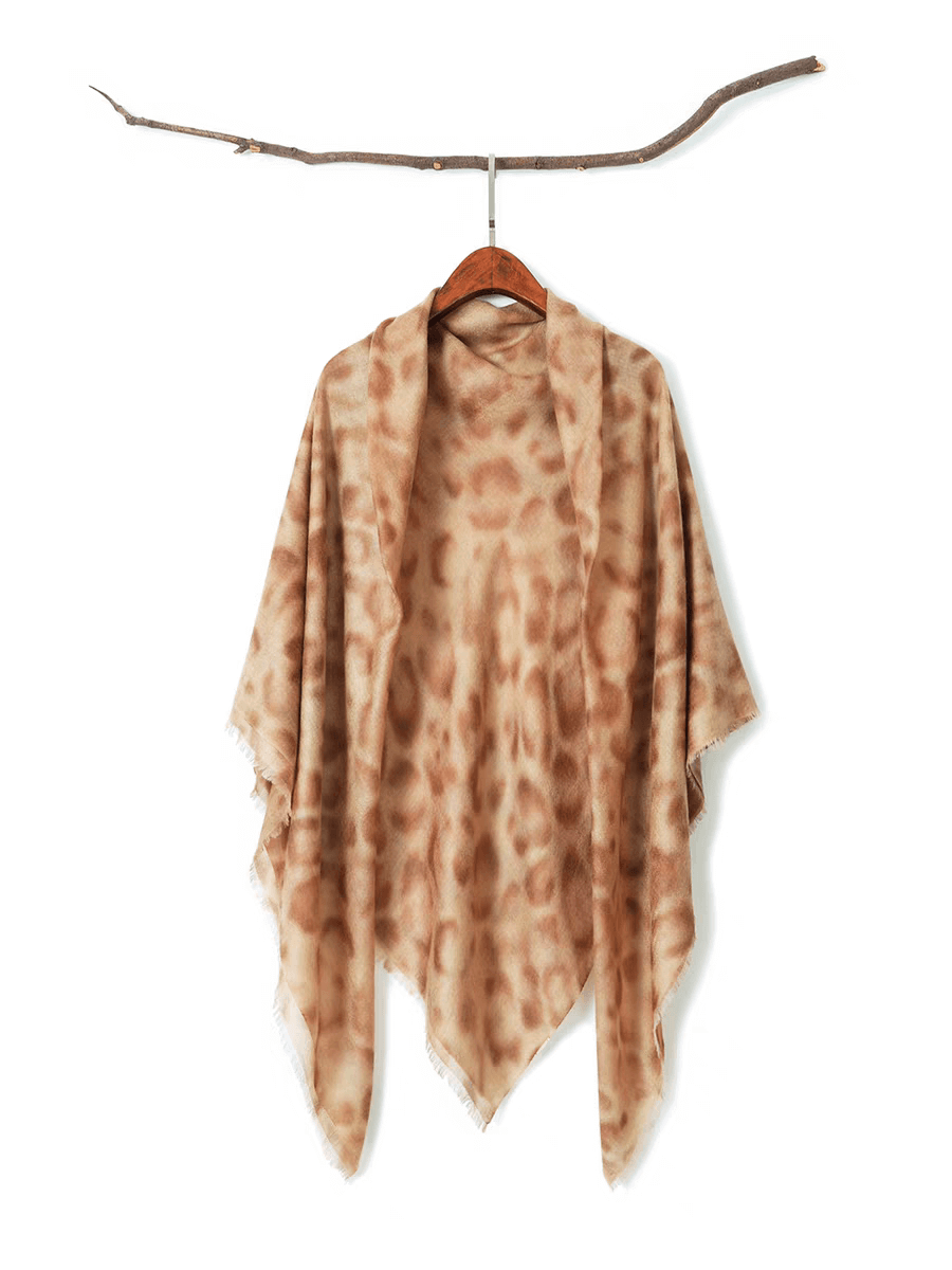 Luxury 100% cashmere leopard print shawl scarf draped over a white chair, showcasing oversized 140cm x 140cm design and lightweight texture.