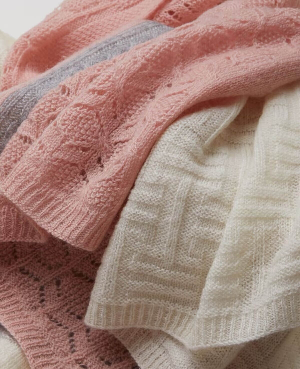 Close-up of 10% cashmere 90% wool fabric highlighting cable-knit braids, lace-knit openwork, and three-tone color blending.