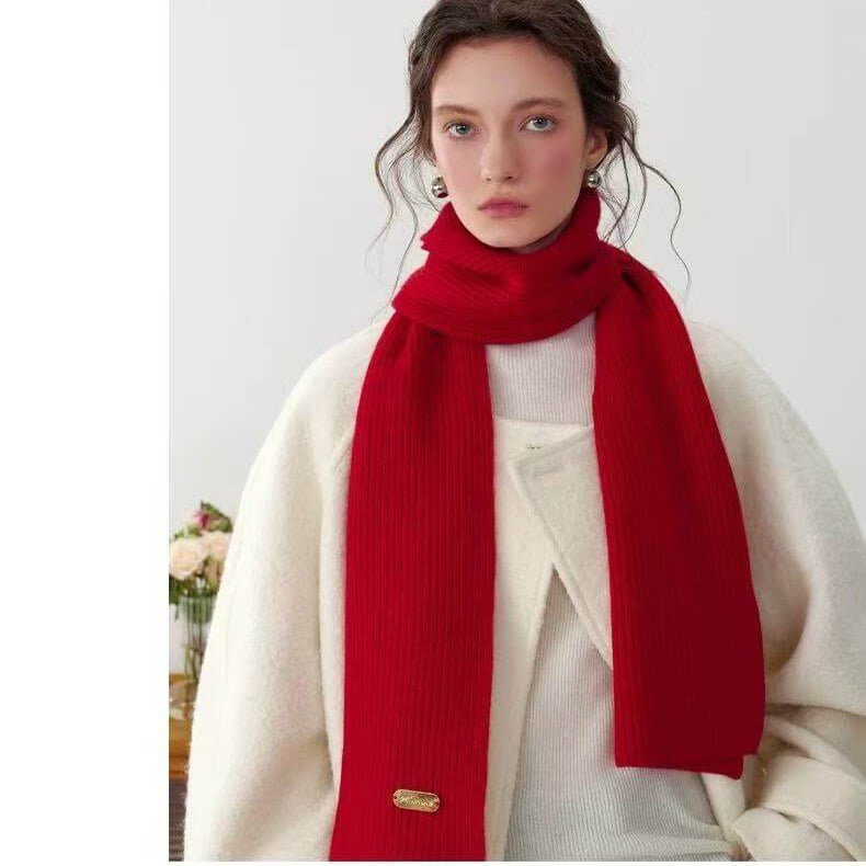Woman wearing a red 100% cashmere ribbed scarf with a white background