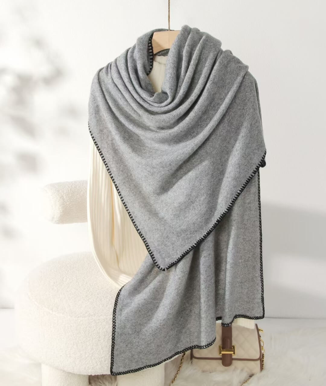Gray 100% cashmere scarf draped over a chair with a white background
