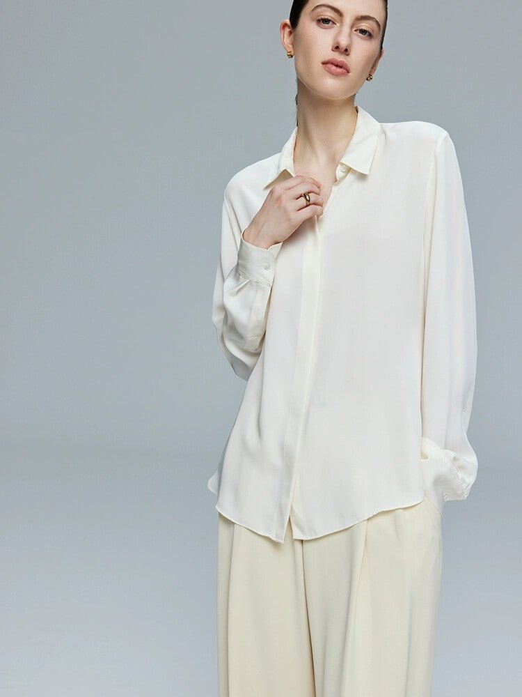 Woman wearing a white 100% silk blouse and beige pants 