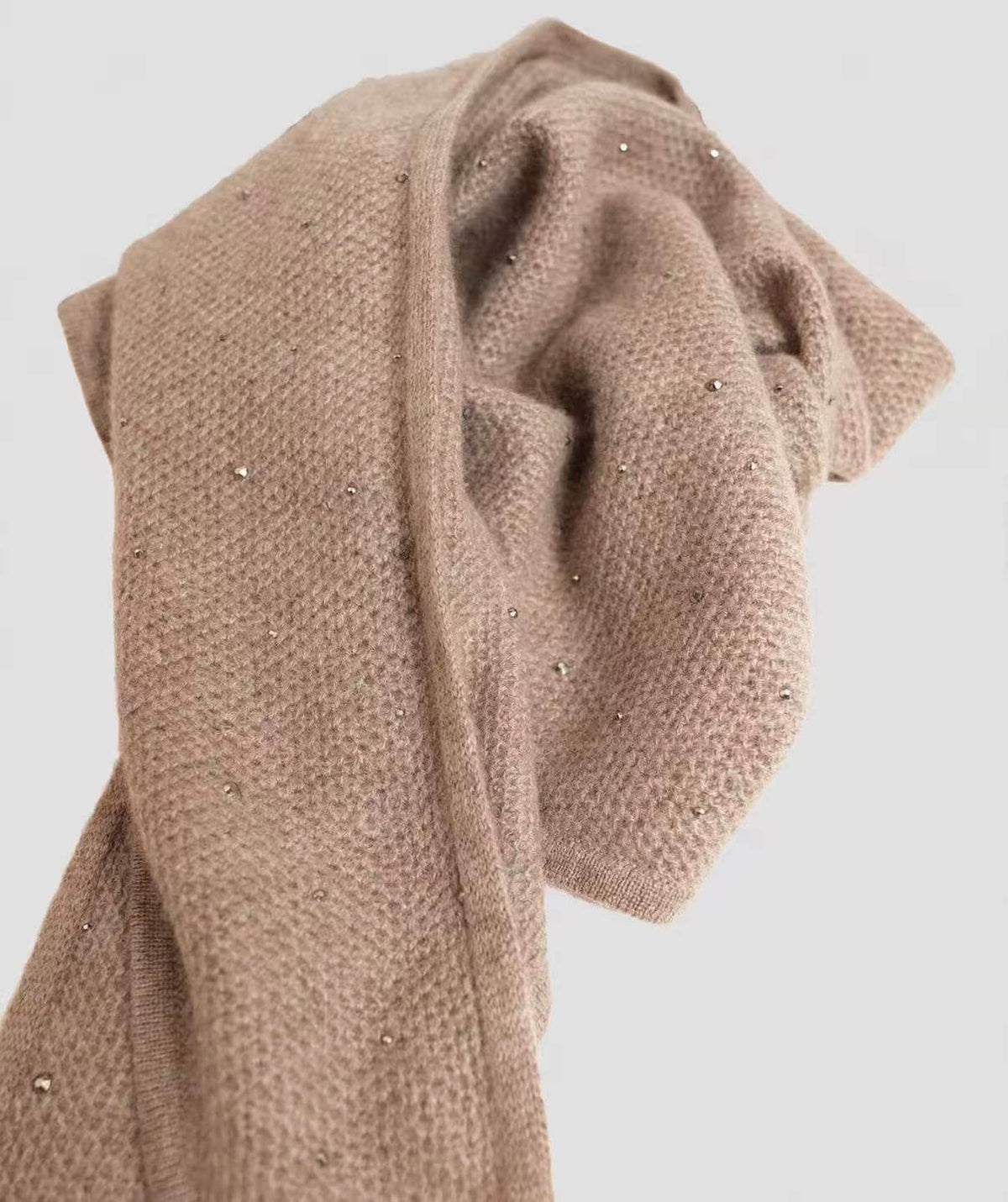 Close-up of rhinestone embellishments on a soft 100% cashmere triangle scarf with a fine texture and subtle sparkle