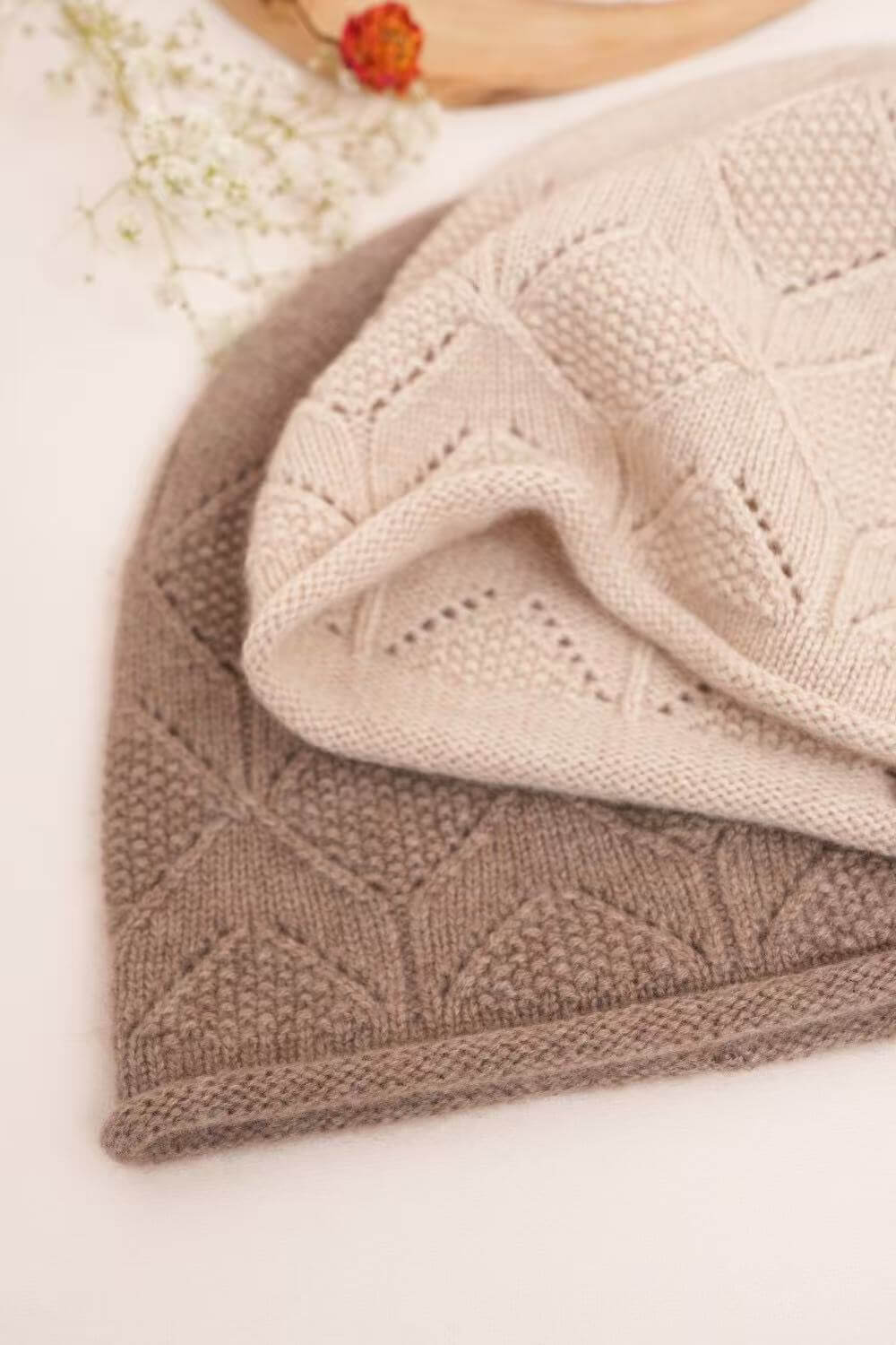 Diamond pointelle cashmere beanies featuring textured stitches and naturally rolled edges.