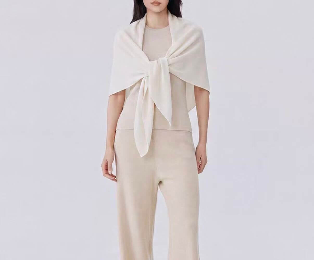 Elegant woman styling a lightweight cashmere triangle shawl with a coat for a sophisticated fall look