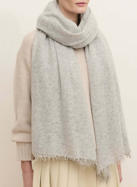 Light heather gray oversized cashmere wrap with fine fabric texture, soft folds, and hand-finished fringe along the edges.