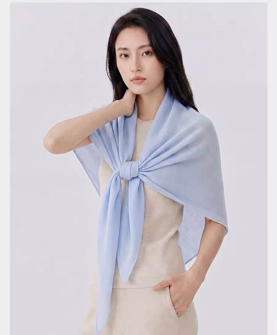 Soft 100% cashmere triangle shawl draped over shoulders for a minimalist quiet luxury winter outfit