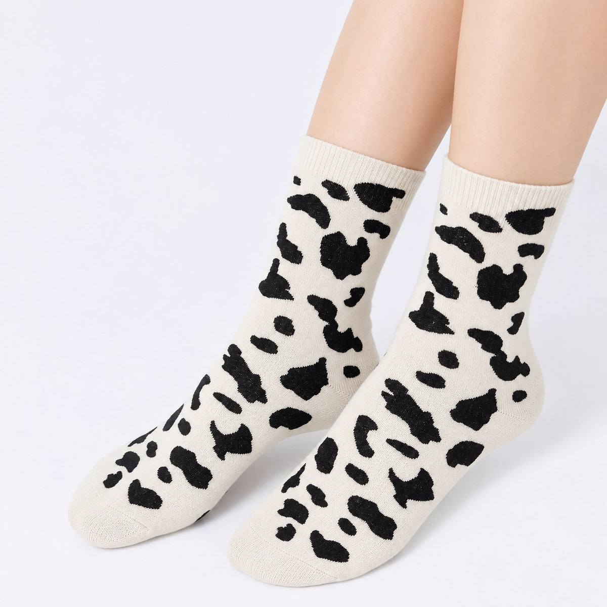 Model standing wearing white cow print cashmere-blend crew socks