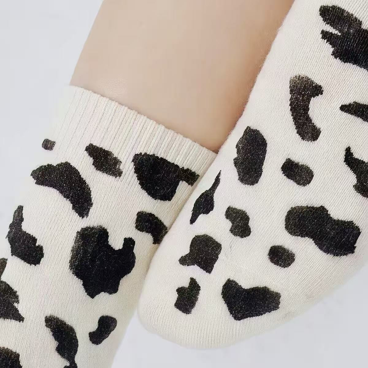 Close-up of black cow print pattern on white cashmere-blend crew socks