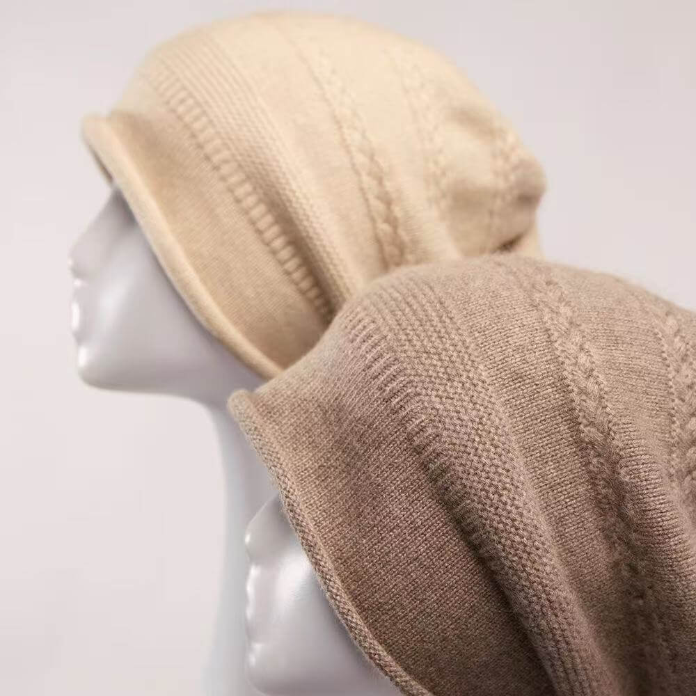 Two knitted slouchy beanies in warm neutral tones displayed on white mannequin heads against a light gray background.