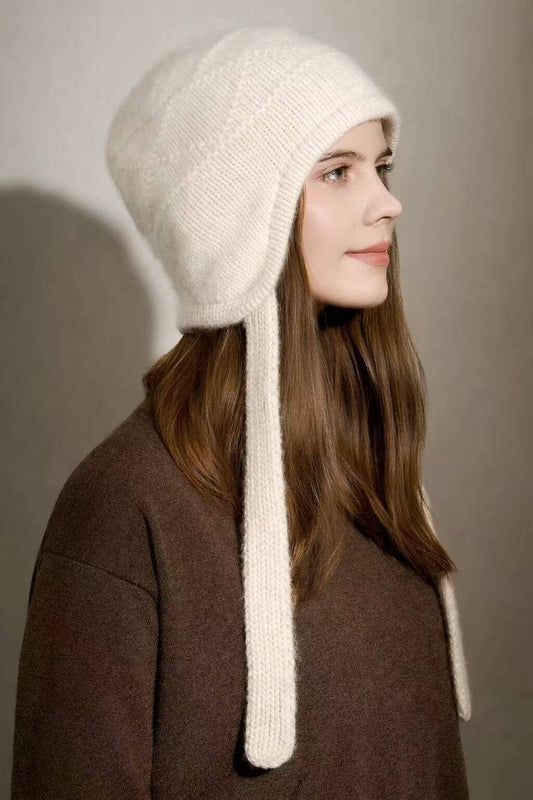 White 100% cashmere diamond knit earflap hat in luxury winter style.