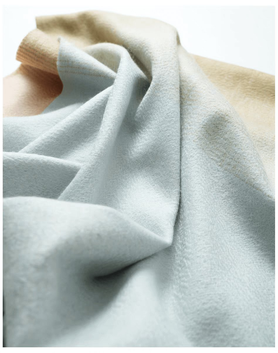Draped ombré cashmere shawl showing the grey to beige gradient transition