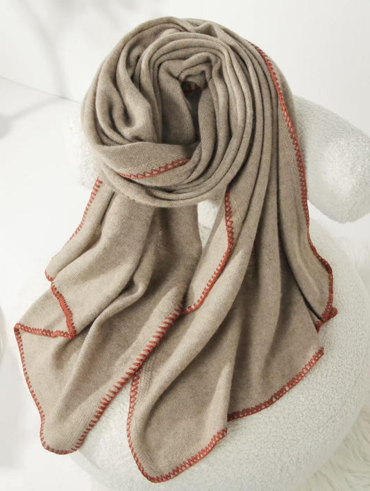 Beige scarf with red stitching draped over Wrap Yourself in Timeless Luxury: Pure 100% Cashmere Scarf