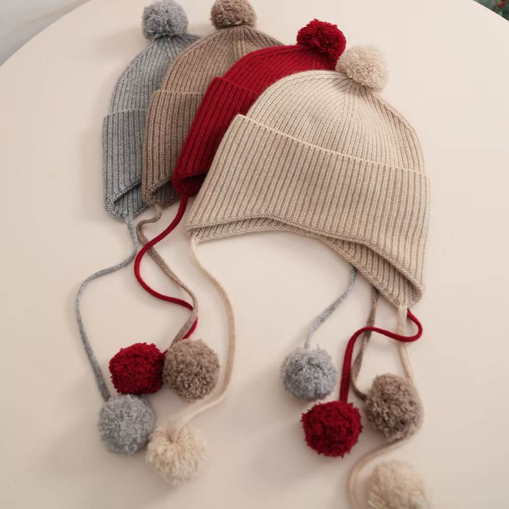 Styled look of luxury 100 percent cashmere pom pom earflap hat ,Close-up of soft luxury cashmere pom pom earflap hat texture